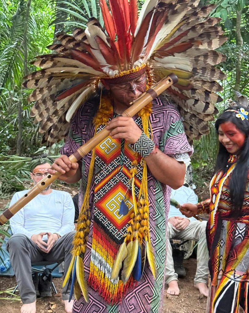Huni Kuin spiritual leader playing a traditional flute during an Amazon ceremony in Acre, Brazil